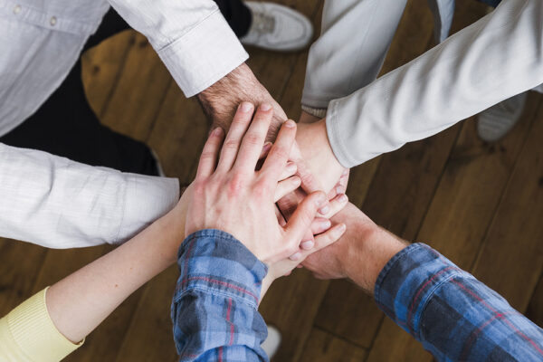 elevated-view-businesspeople-stacking-hands-each-other-edited-scaled
