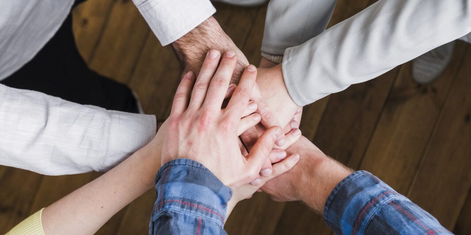 elevated-view-businesspeople-stacking-hands-each-other-edited